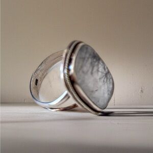 This piece is a black rutilated quartz ring set in sterling silver. Size 8